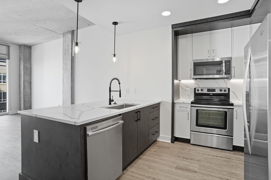 A modern kitchen with a large island and stainless steel appliances.