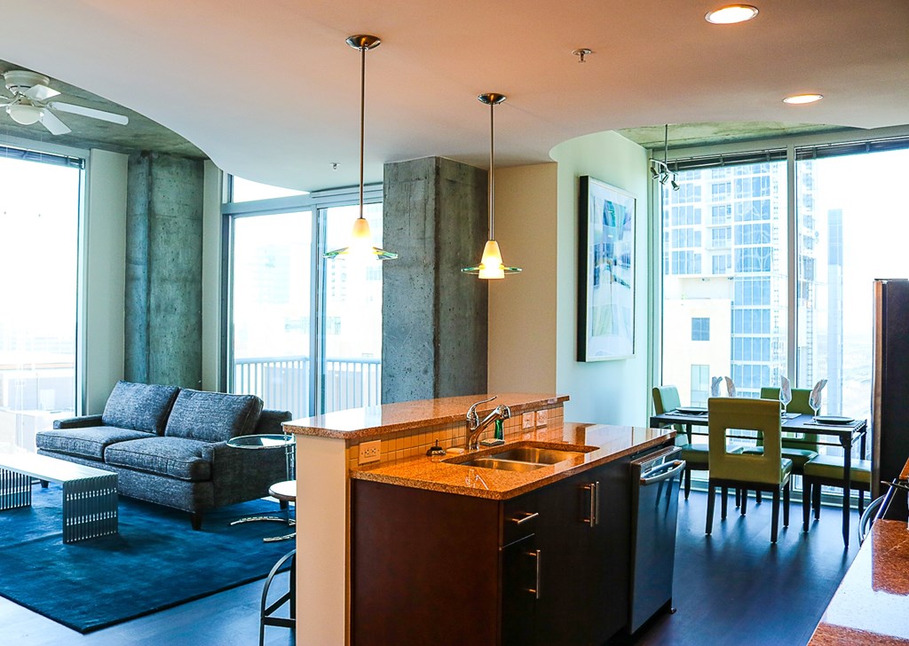 A modern kitchen with a large island and a dining table with chairs.