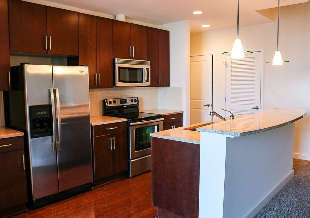 A kitchen with dark wood cabinets and stainless steel appliances.