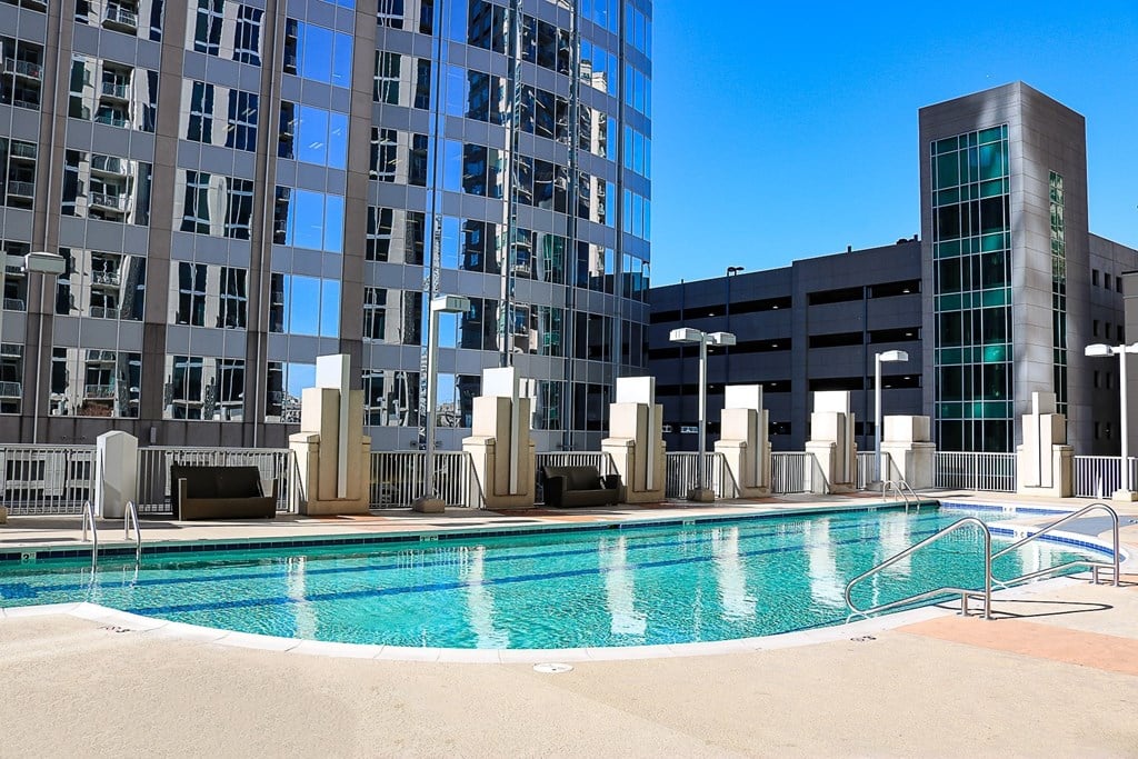 A large swimming pool in front of a tall building.