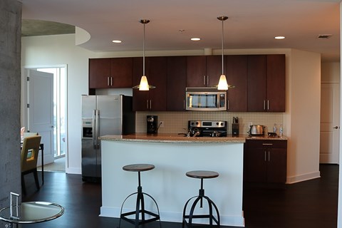 A kitchen with a white counter and brown cabinets.