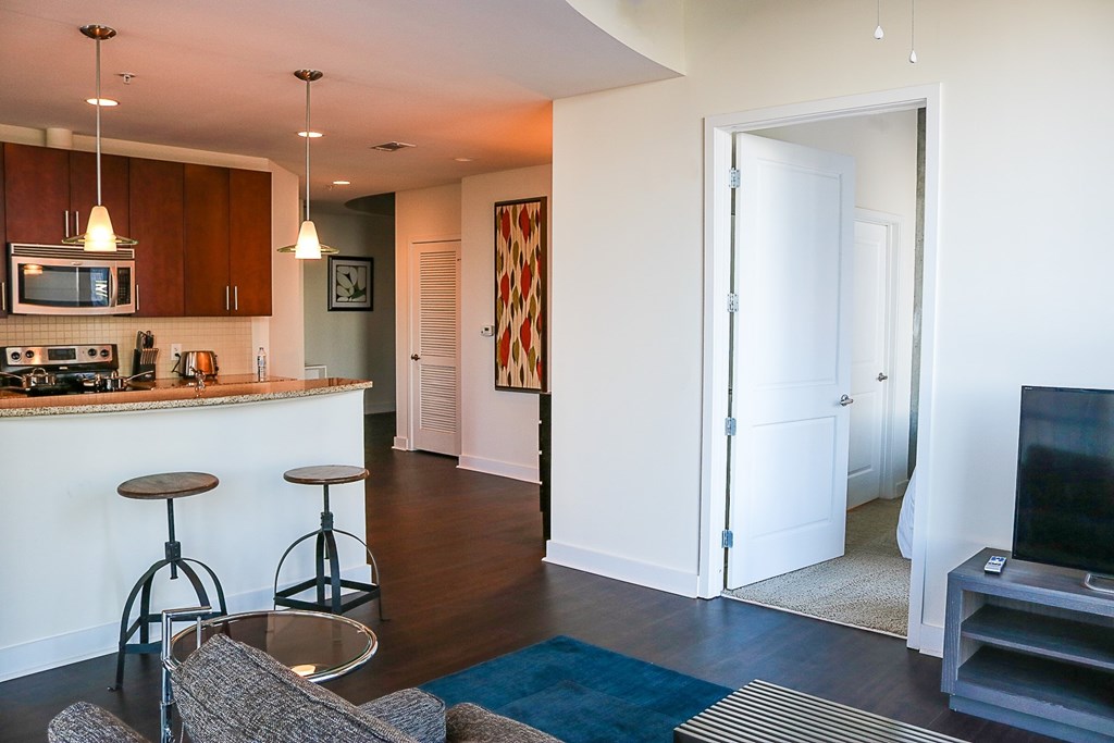 A kitchen with a bar and a grey couch.