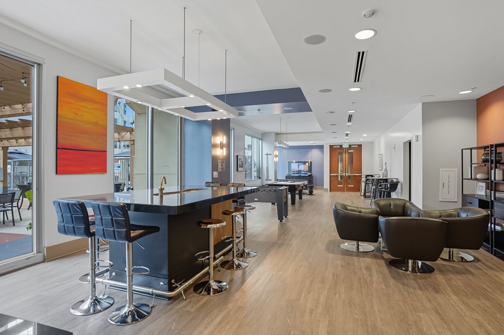 A modern bar area with a black counter and stools.