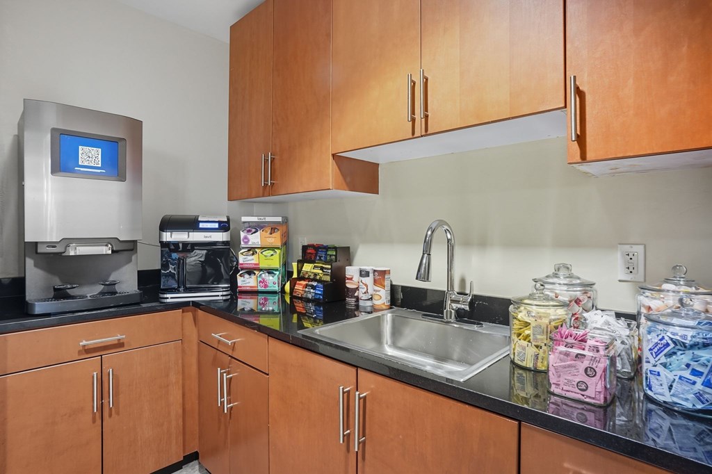 A kitchen with brown cabinets and a black counter top.