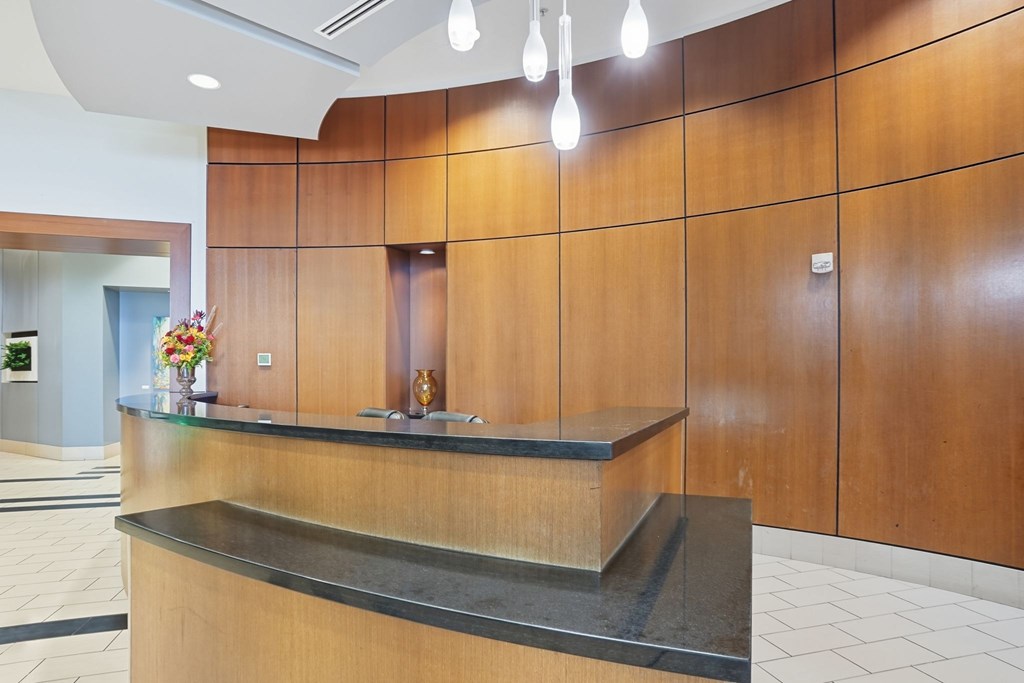 A reception area with a wooden counter and a black granite countertop.