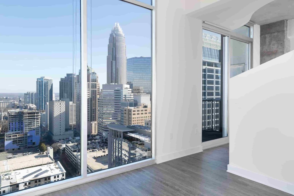 A cityscape is visible through a large window in a modern room.