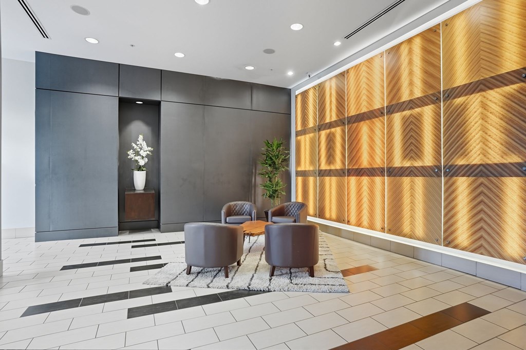 A modern room with a wooden panel wall and a grey sofa.