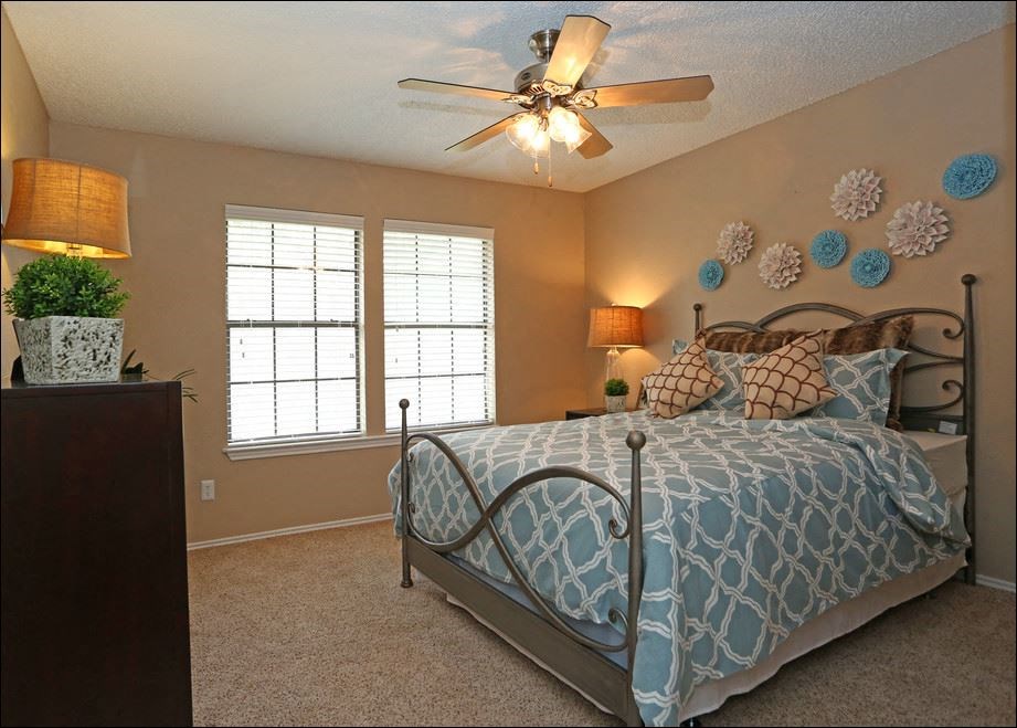 a bedroom with a bed and a ceiling fan