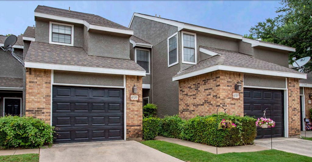 a house with black garage doors in front of it
