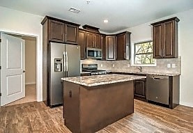 A kitchen with brown cabinets and a granite counter top.