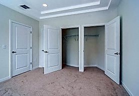 A room with white doors and carpeted floor.