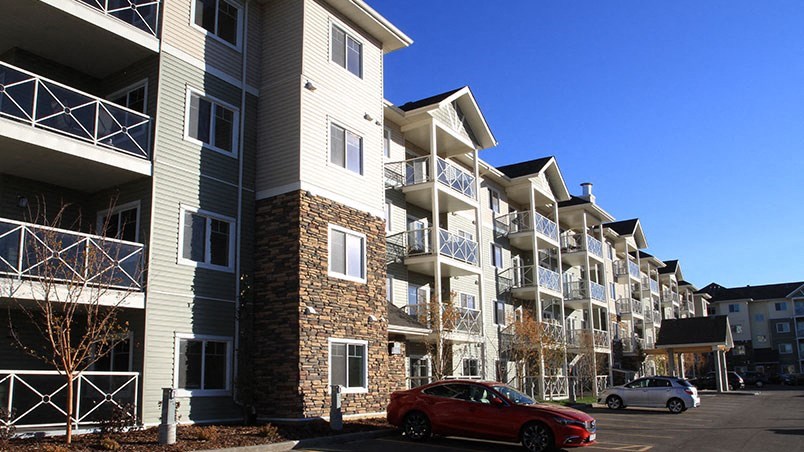 a red car parked in front of an apartment building