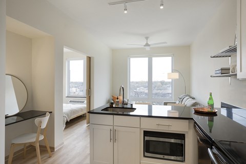 a kitchen with a black counter top and a sink and a window