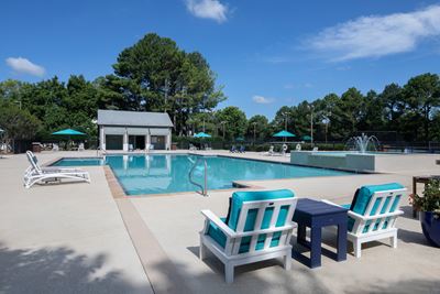 Large pool with deck chairs, lounges, and cabana