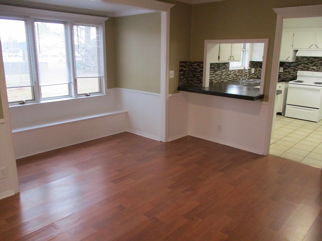 an empty living room with a hard wood floor