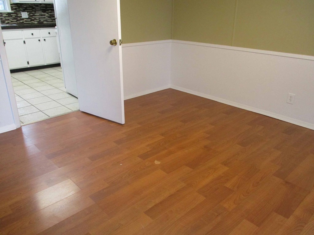 an empty kitchen with wooden floors and a white door