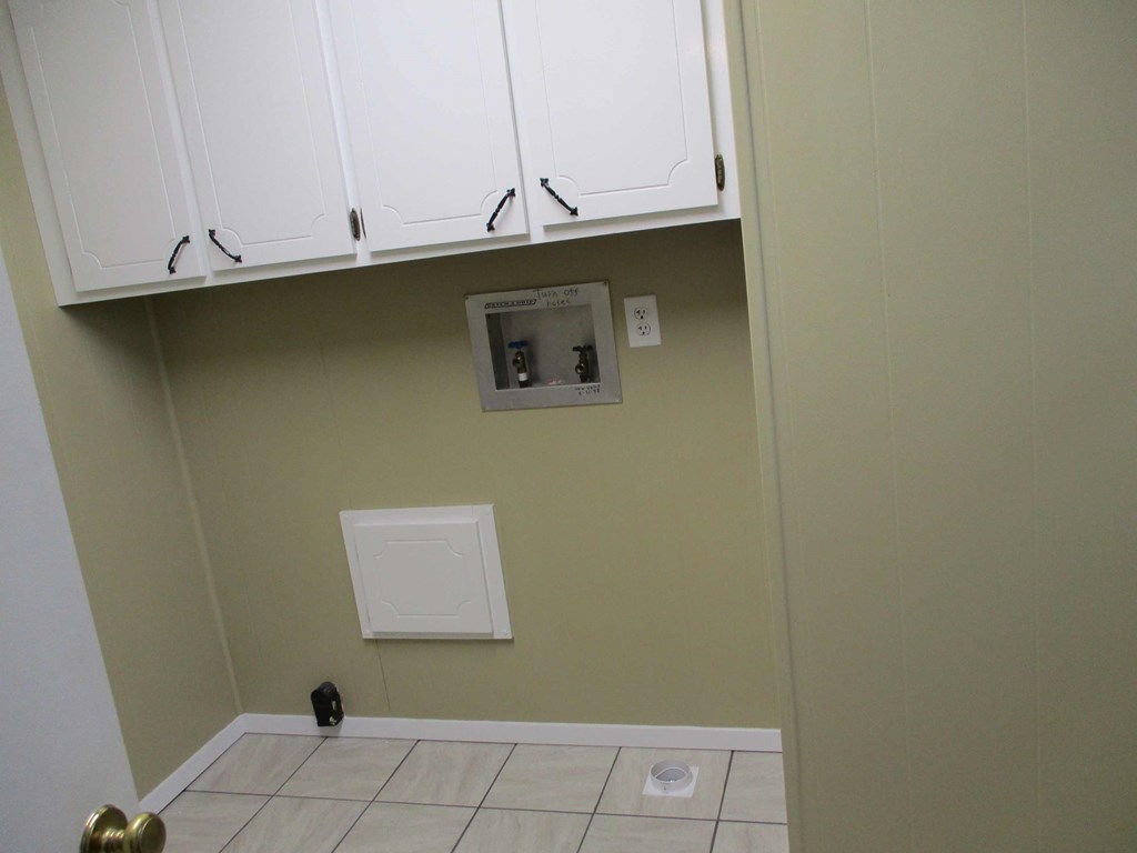 a kitchen with white cabinets and a dishwasher on the wall