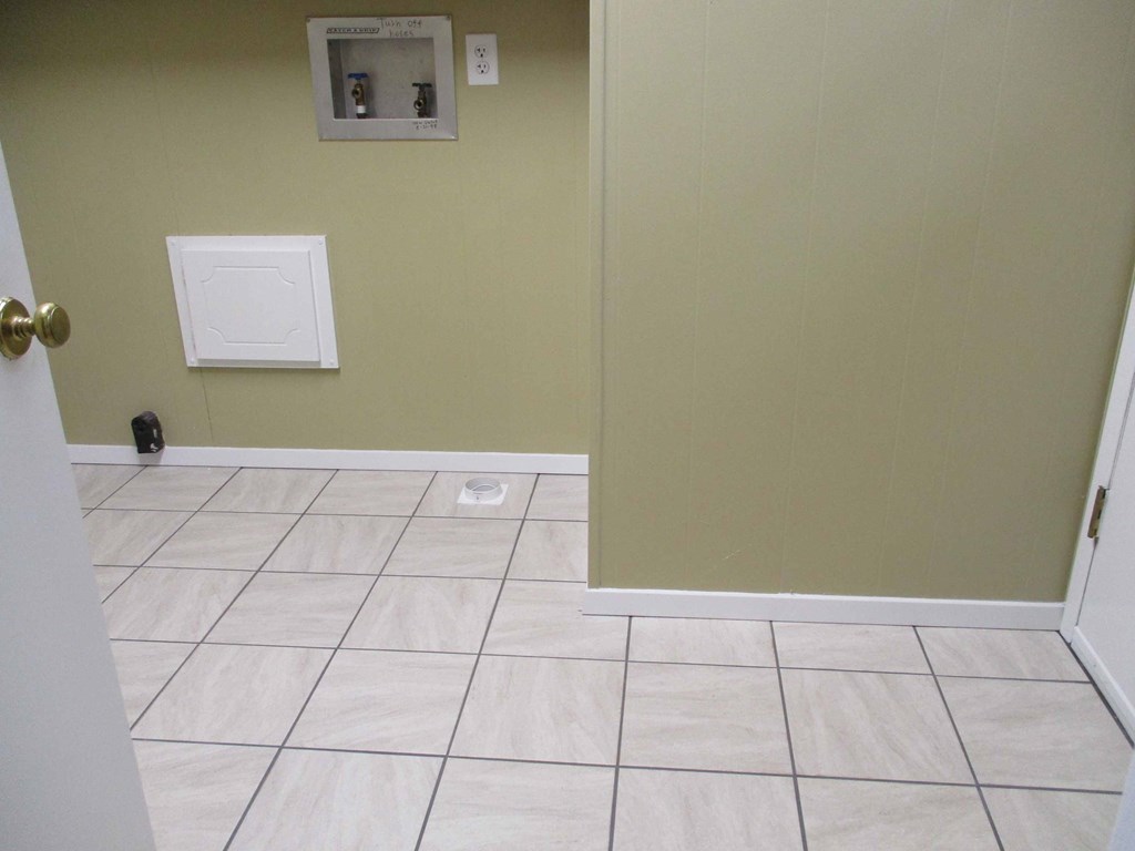 a room with a tiled floor and a wall with a door