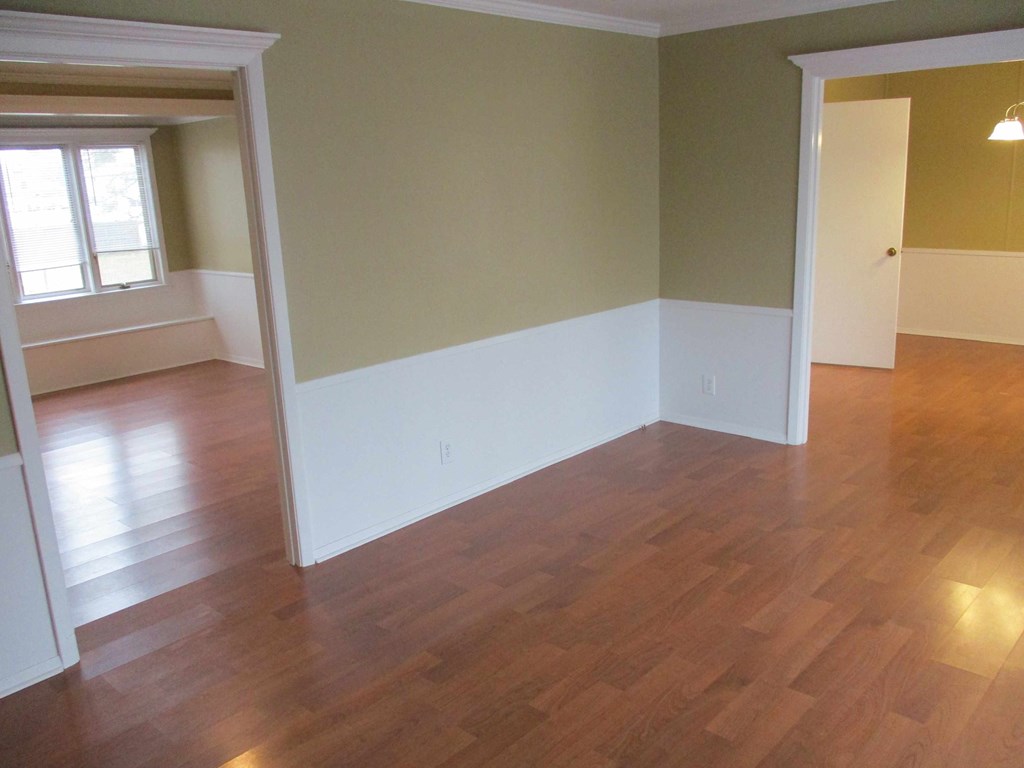 an empty living room with a hard wood floor