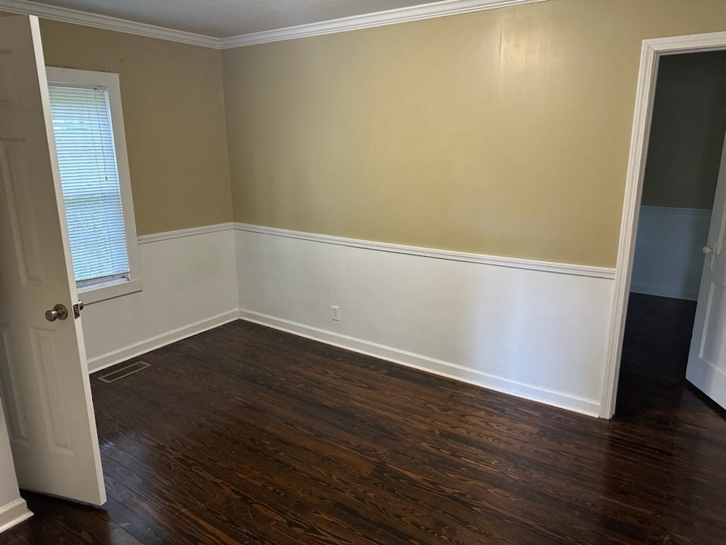 an empty room with wooden floors and a window