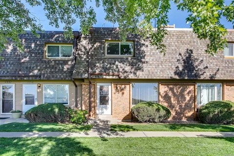 A house with a green lawn in front.