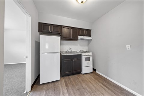 a kitchen with white appliances and brown cabinets and a white refrigerator