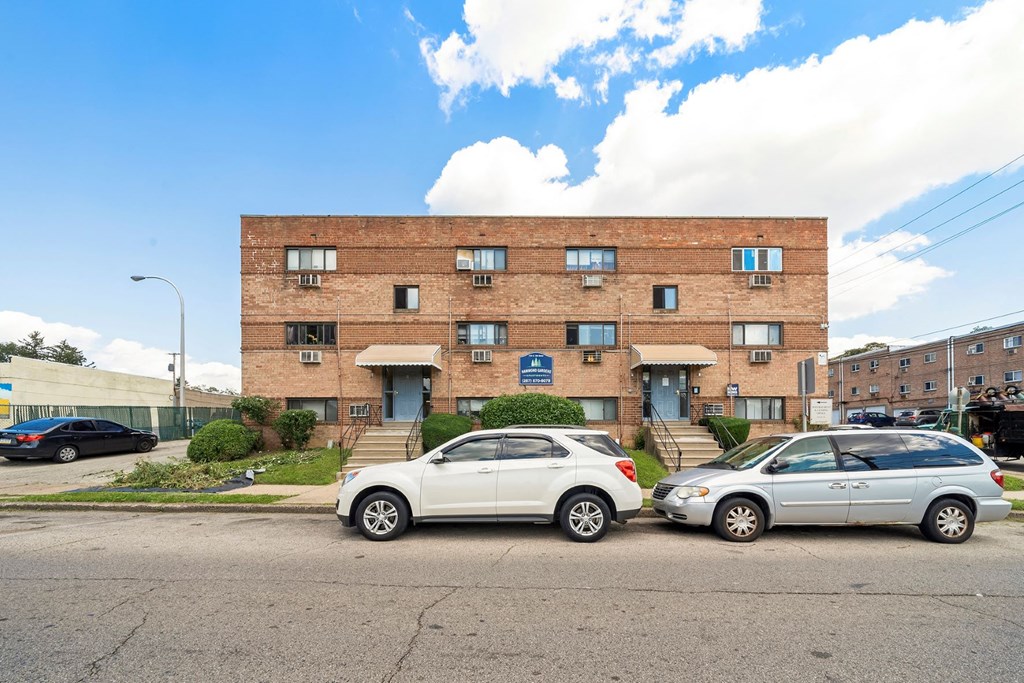 two cars parked in front of a brick building