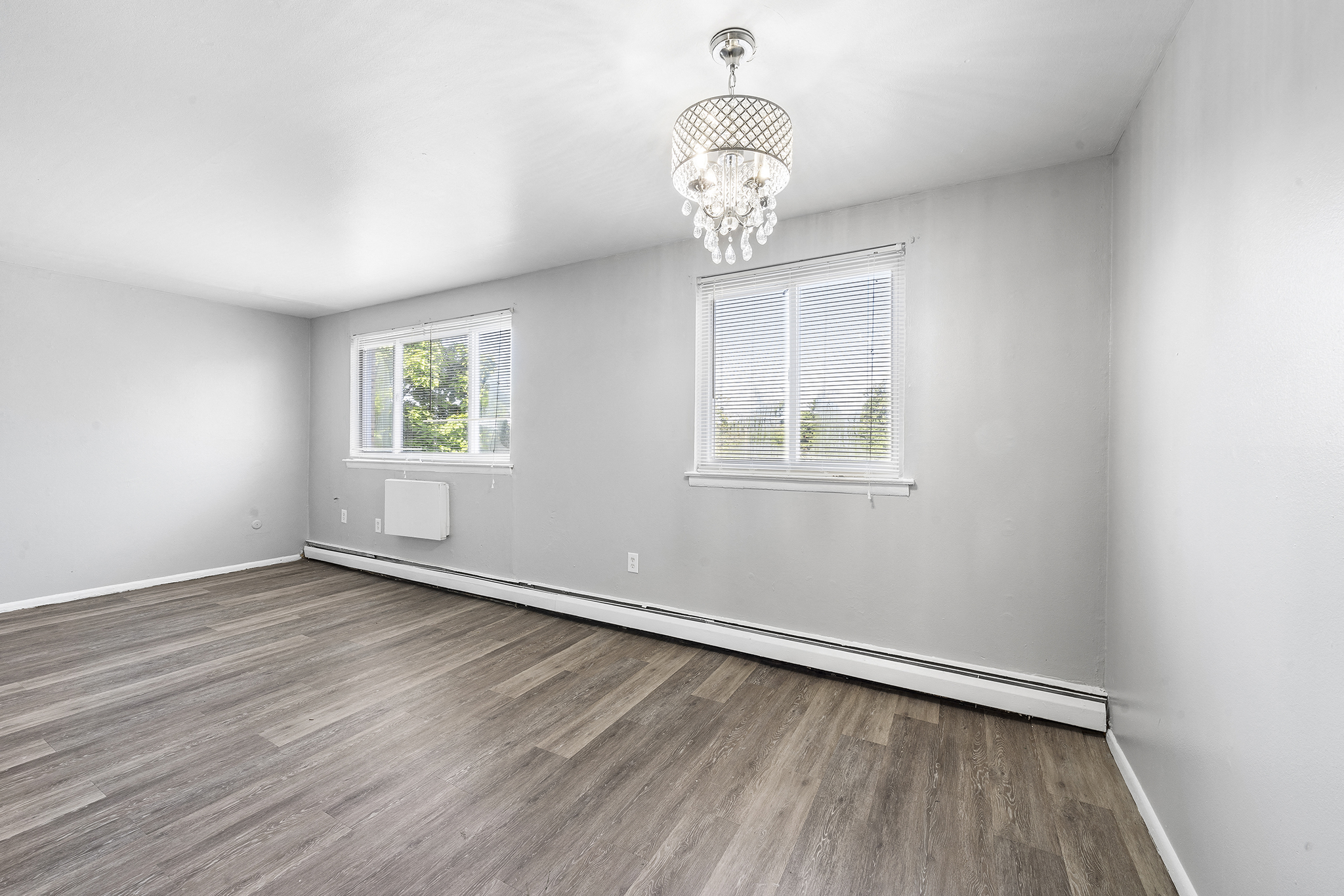 an empty living room with white walls and wood floors