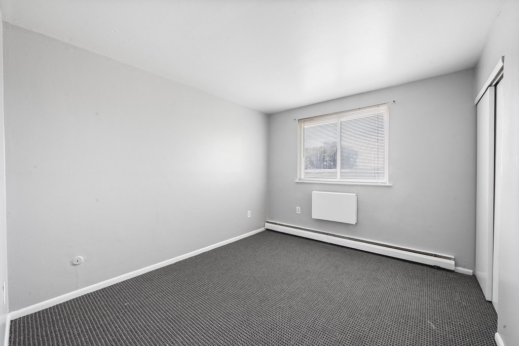 an empty room with white walls and a window