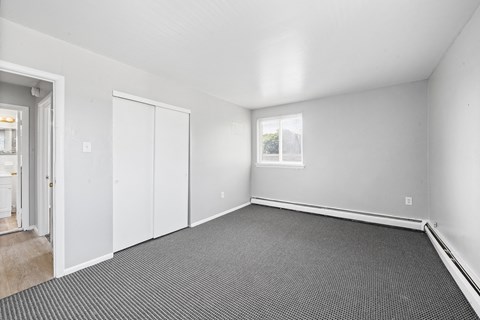 the living room of a house with white walls and a black carpet