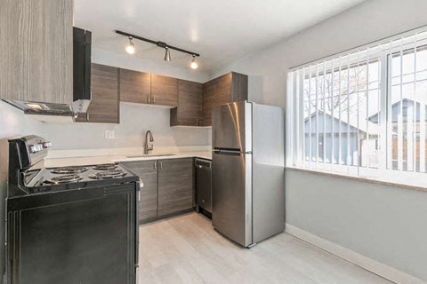 A modern kitchen with a black stove top oven and a silver refrigerator.