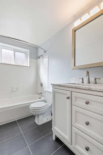 A white bathroom with a toilet, sink, and tub.