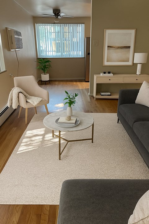A living room with a grey couch, a white chair, and a coffee table.