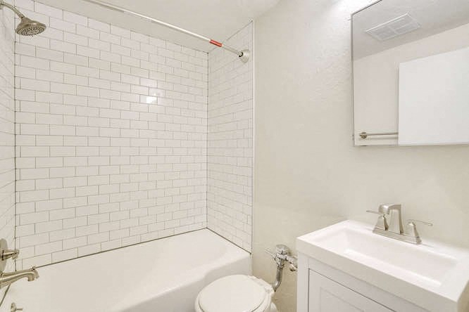 a white bathroom with a toilet and a sink