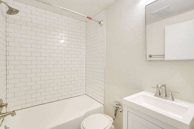 a white bathroom with a toilet and a sink