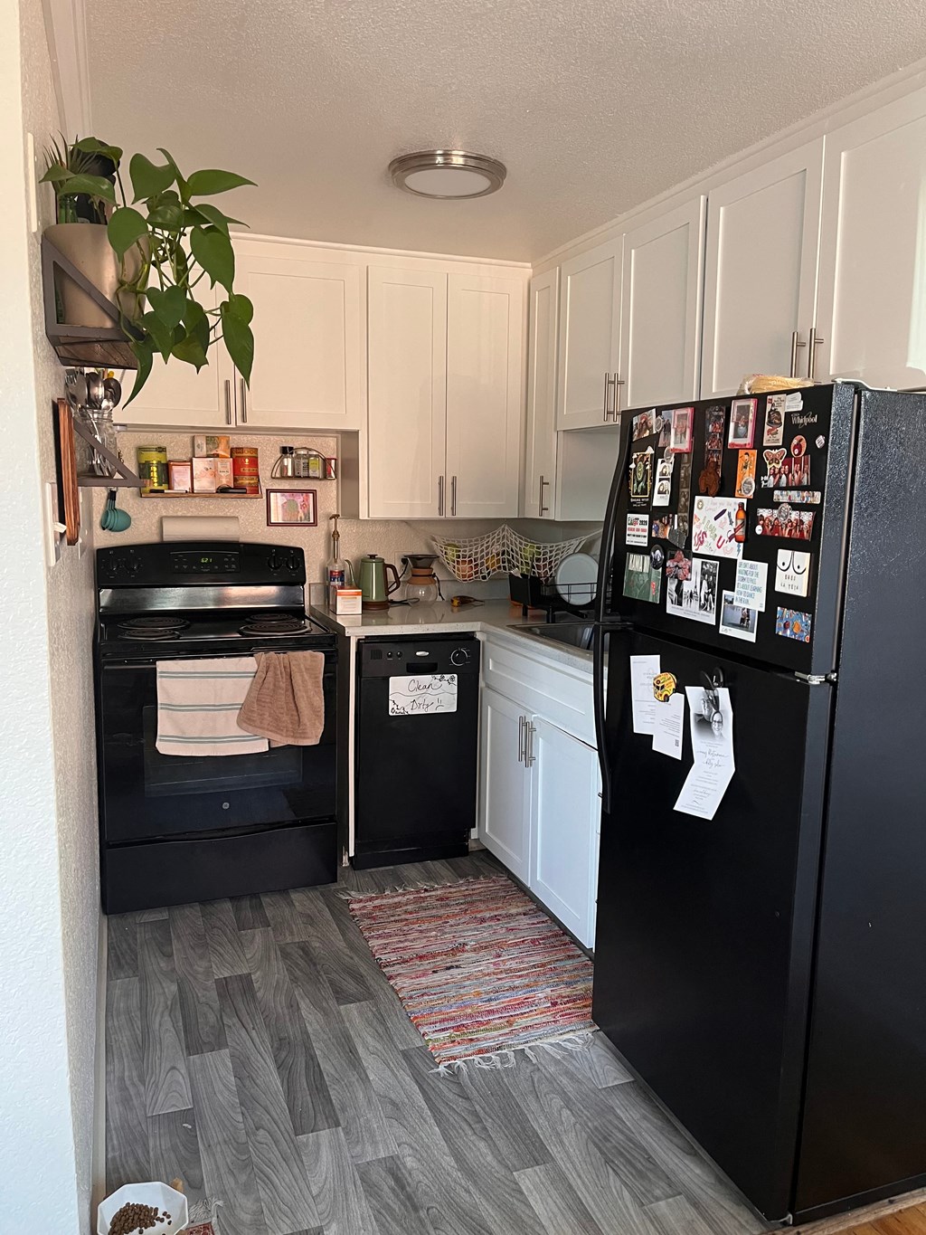 a kitchen with black appliances and white cabinets and a refrigerator