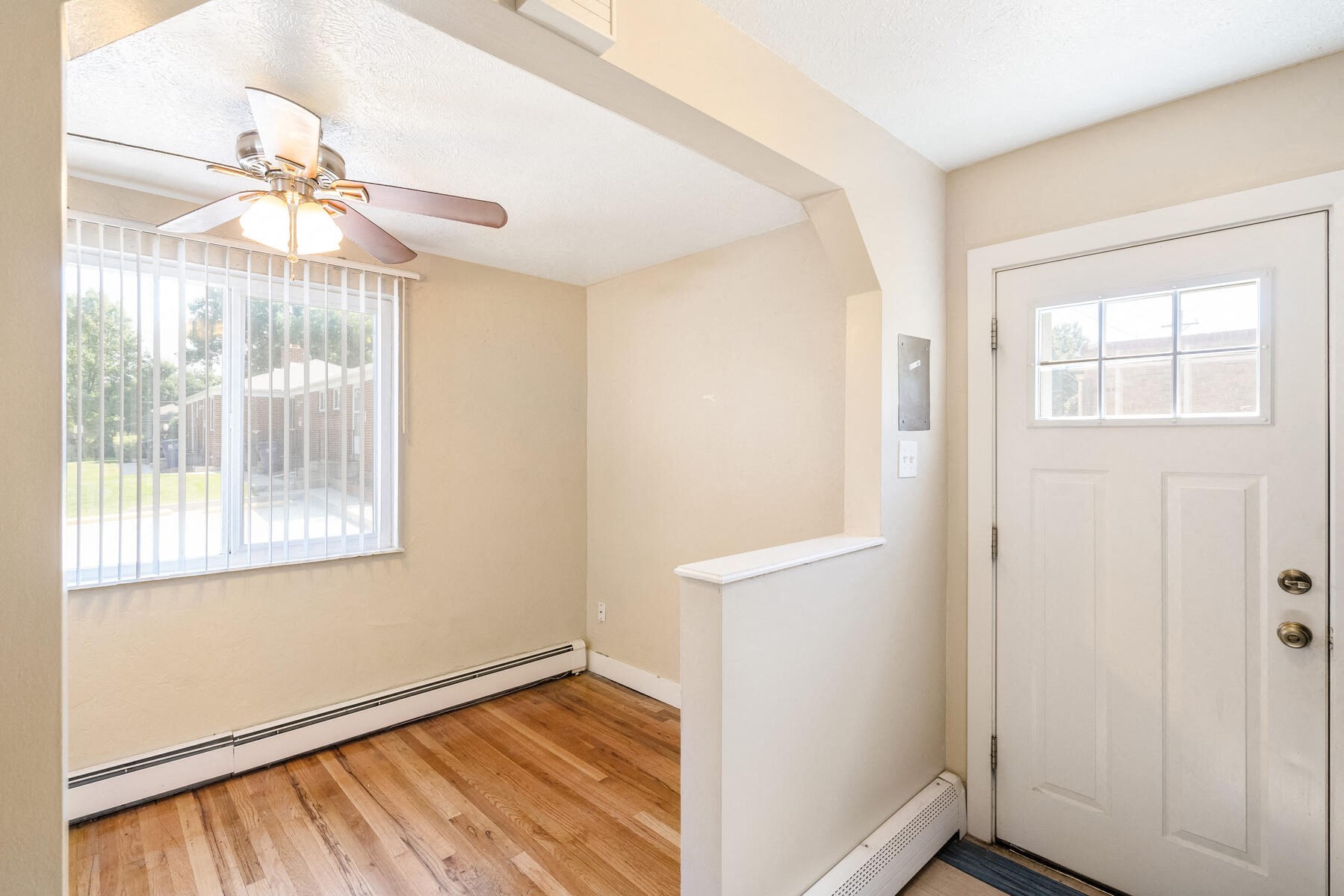 an empty bedroom with a door and a ceiling fan