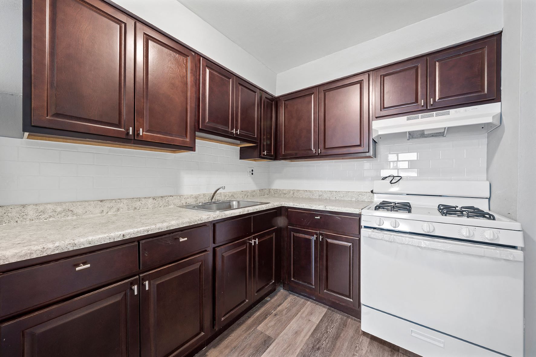 a kitchen with dark wood cabinets and white appliances