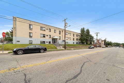 a car parked in front of an apartment building on a city street