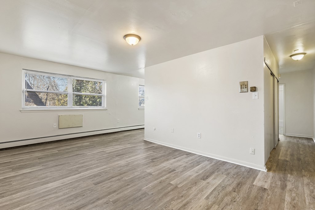 an empty living room with white walls and a window