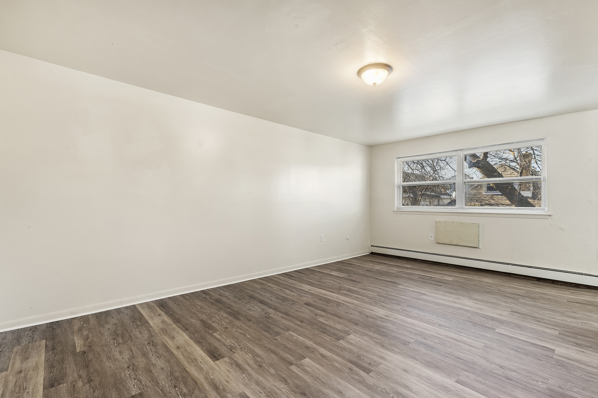 an empty living room with white walls and a window