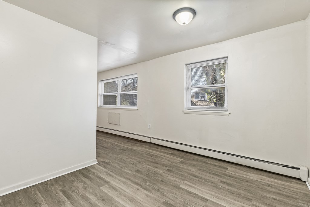 an empty living room with white walls and a window
