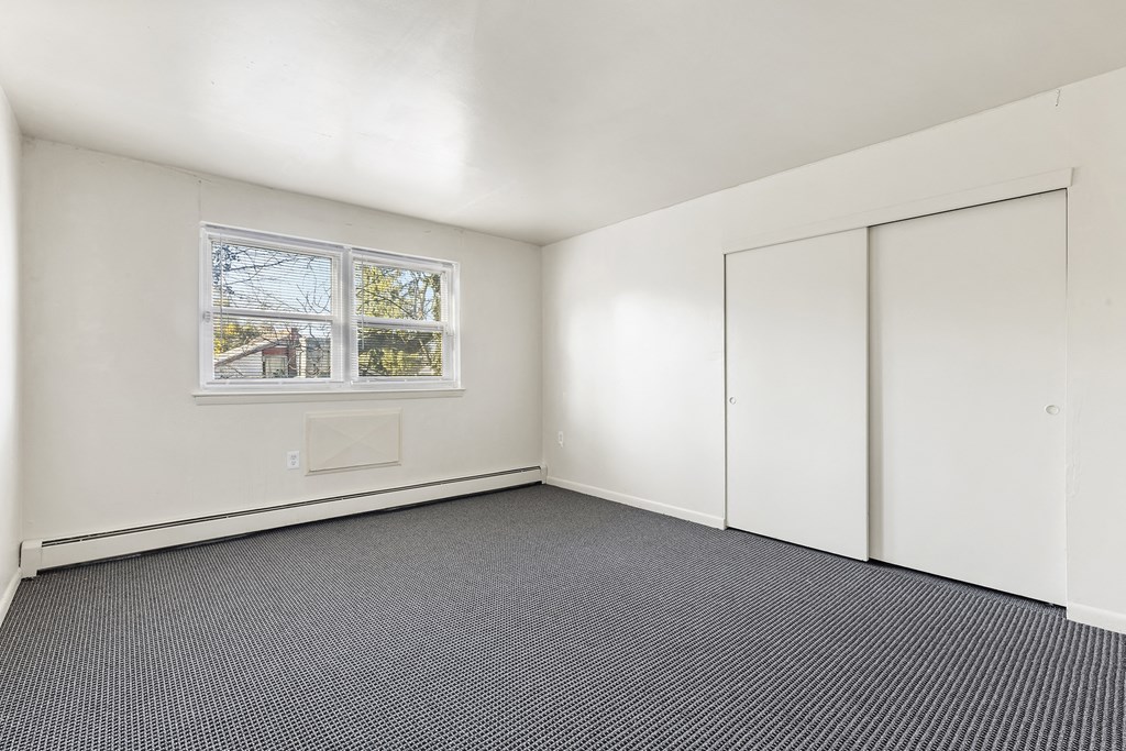 an empty room with carpet and a window