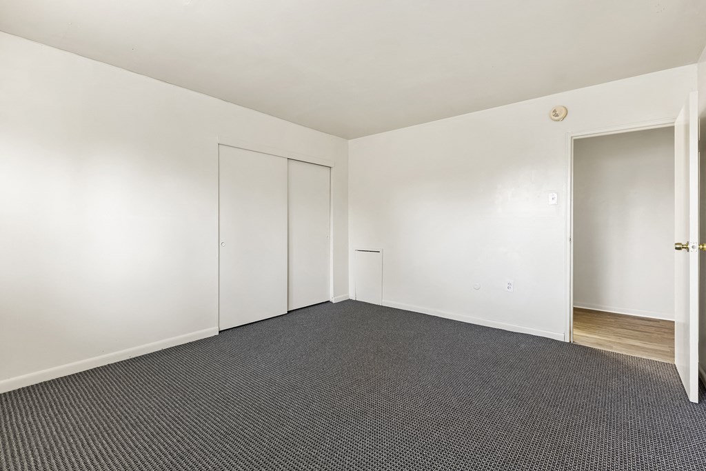 an empty room with carpet and white walls