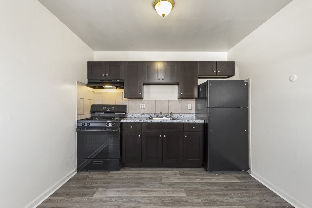 an empty kitchen with black appliances and black cabinets