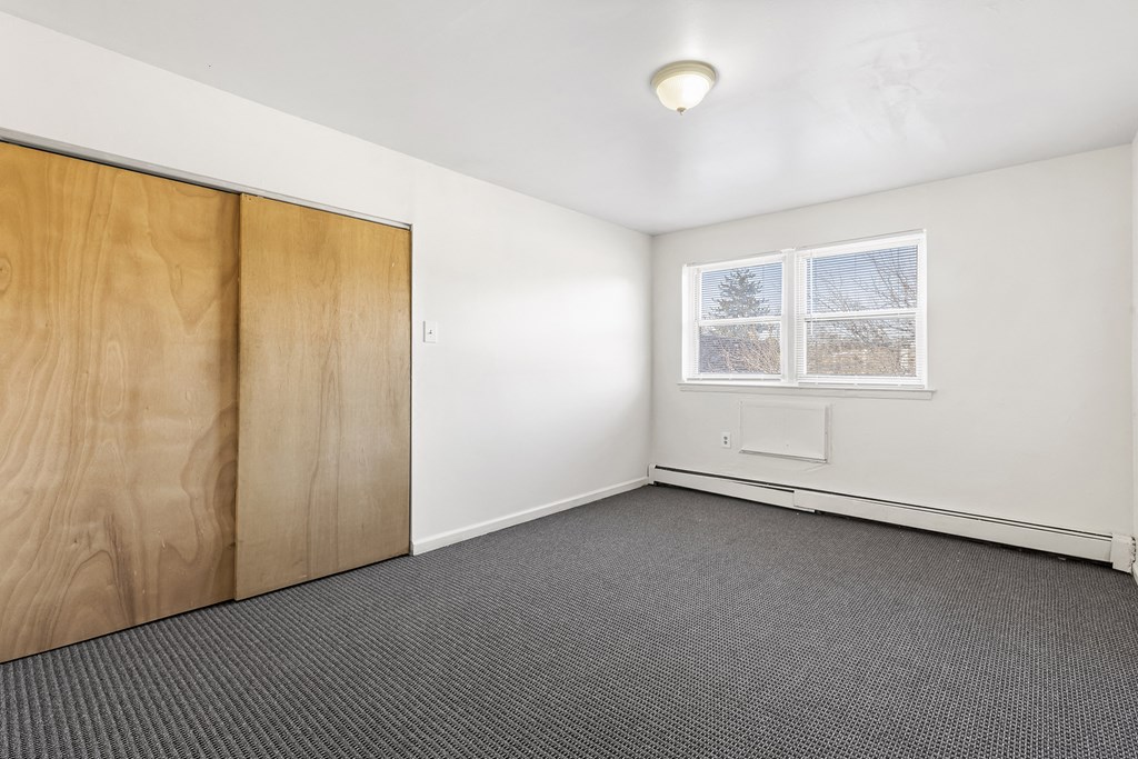 an empty room with a window and a wooden door