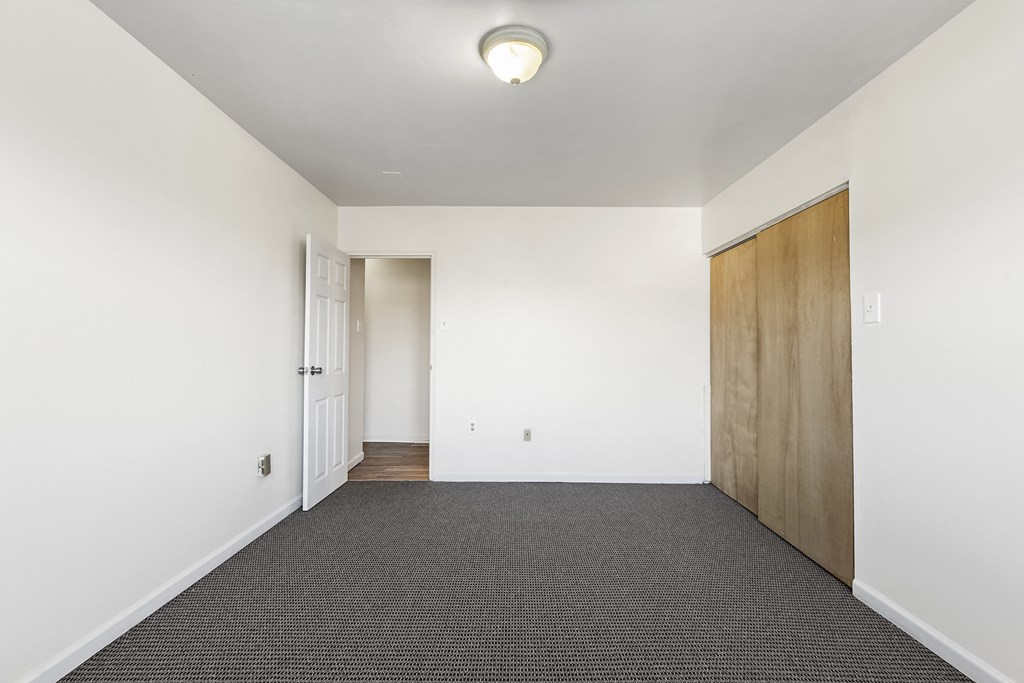 an empty room with white walls and a wooden door