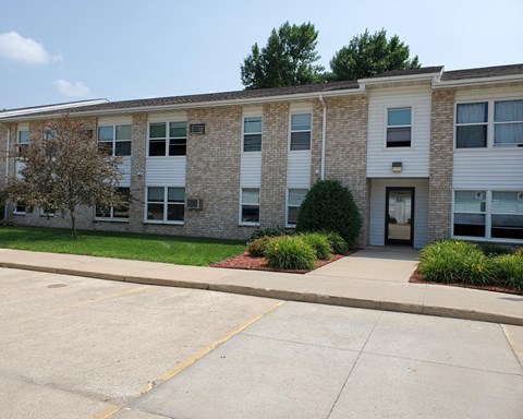 an apartment building with a sidewalk in front of it