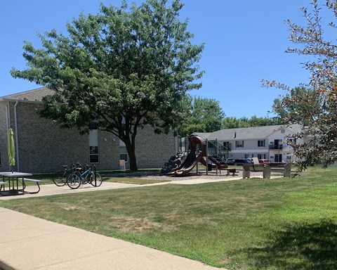 a playground in front of a building with a tree