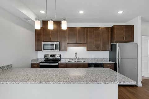 a kitchen with granite counter tops and wooden cabinets
